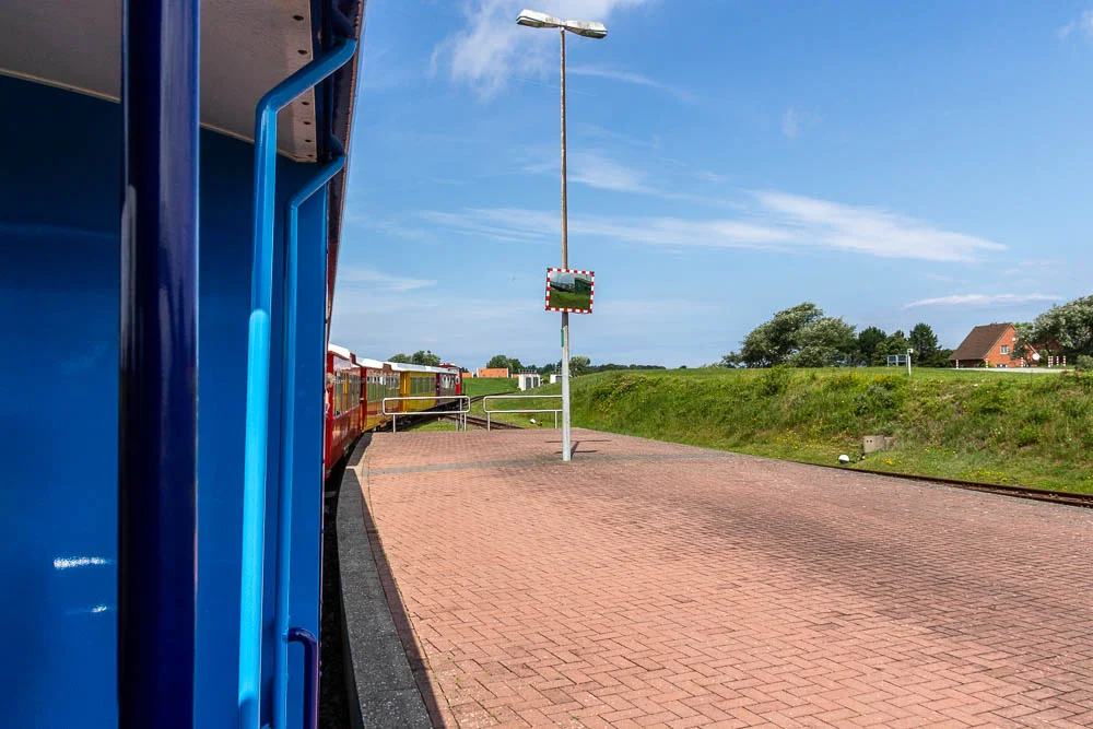 Die Inselbahn von Langeoog steht am kleinen Bahnhof nahe dem Hafen.