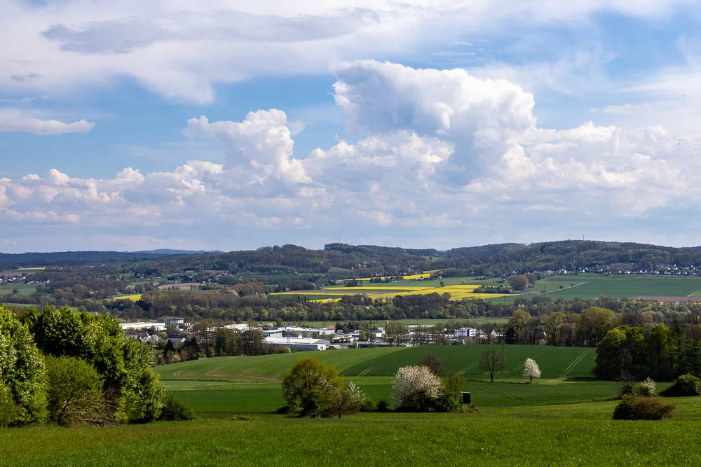 Blick von Fröndenberg-Hohenheide über das Ruhrtal im Frühling mit Feldern, Bäumen und Wolkenhimmel