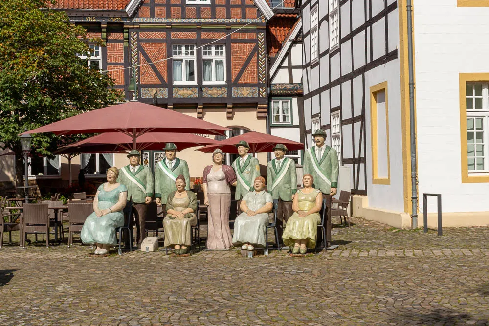 Eine Gruppe von Figuren der Ausstellung Alltagsmenschen steht auf einem Platz in der Altstadt