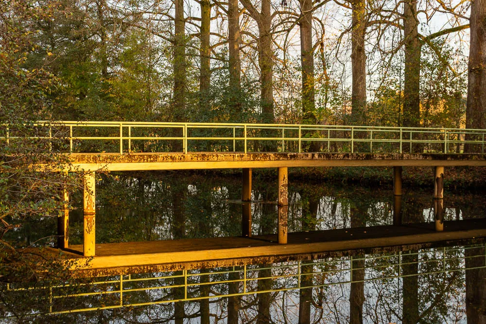 Fußgängerbrücke mit Spiegelung im ruhigen Wasser an einem Herbstnachmittag in Wickede an der Ruhr.