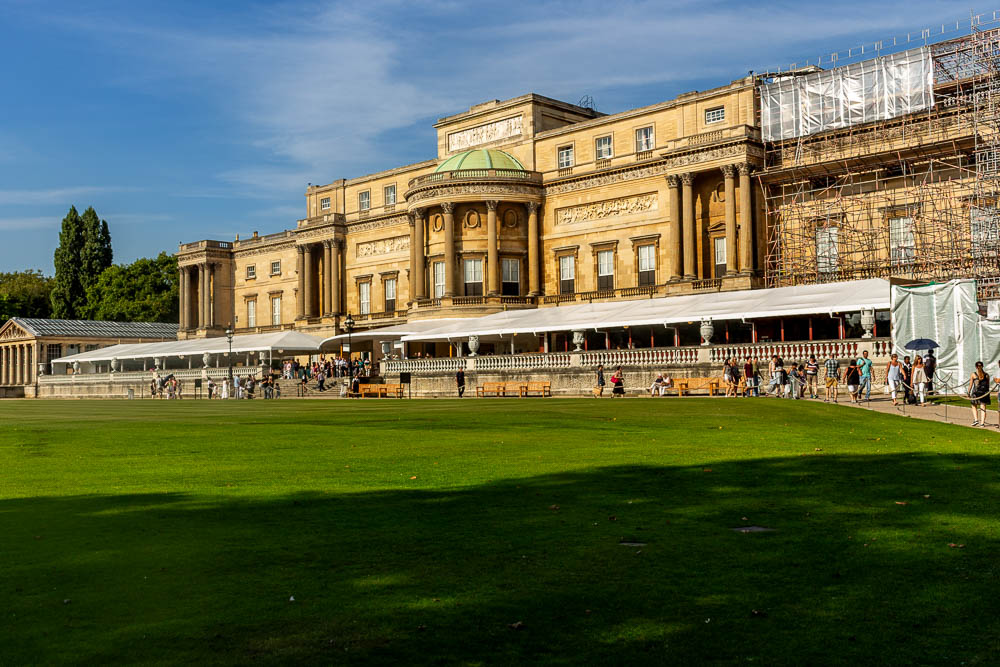 Rückseite des Buckingham Palace mit Rasenfläche und Besuchern im Schlossgarten
