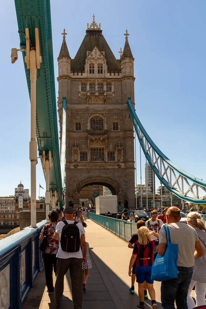 Fußgänger überqueren den Gehweg der Tower Bridge in London