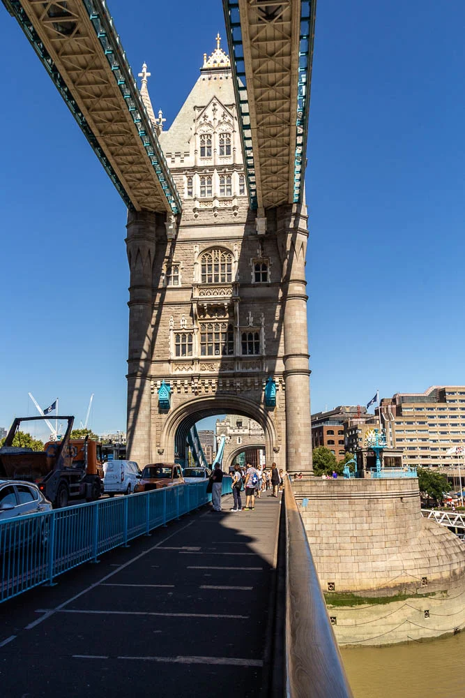 Fußweg und Brückenturm der Tower Bridge in London.