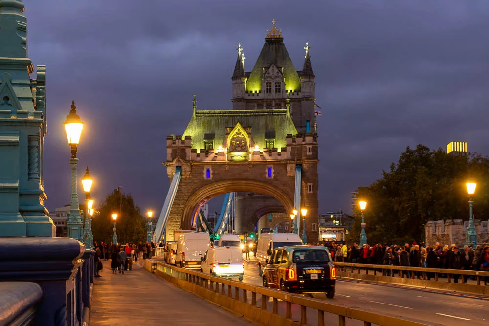 Tower Bridge in London während der Abenddämmerung mit Verkehr auf der Fahrbahn