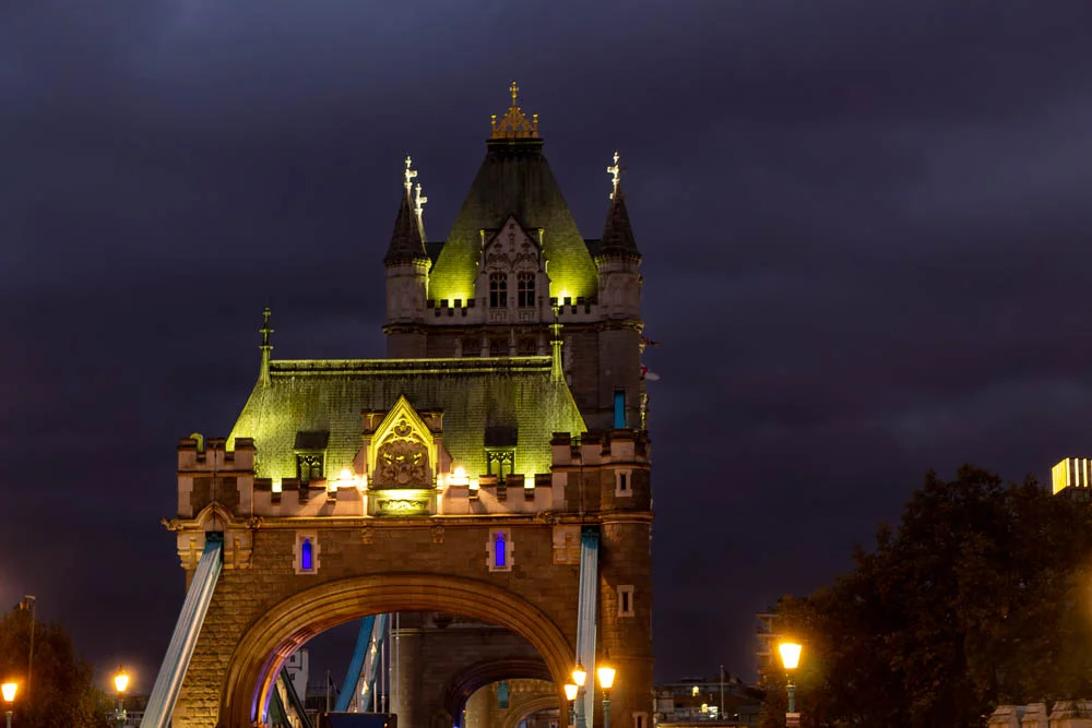 Beleuchteter Turm der Tower Bridge bei Nacht in London.