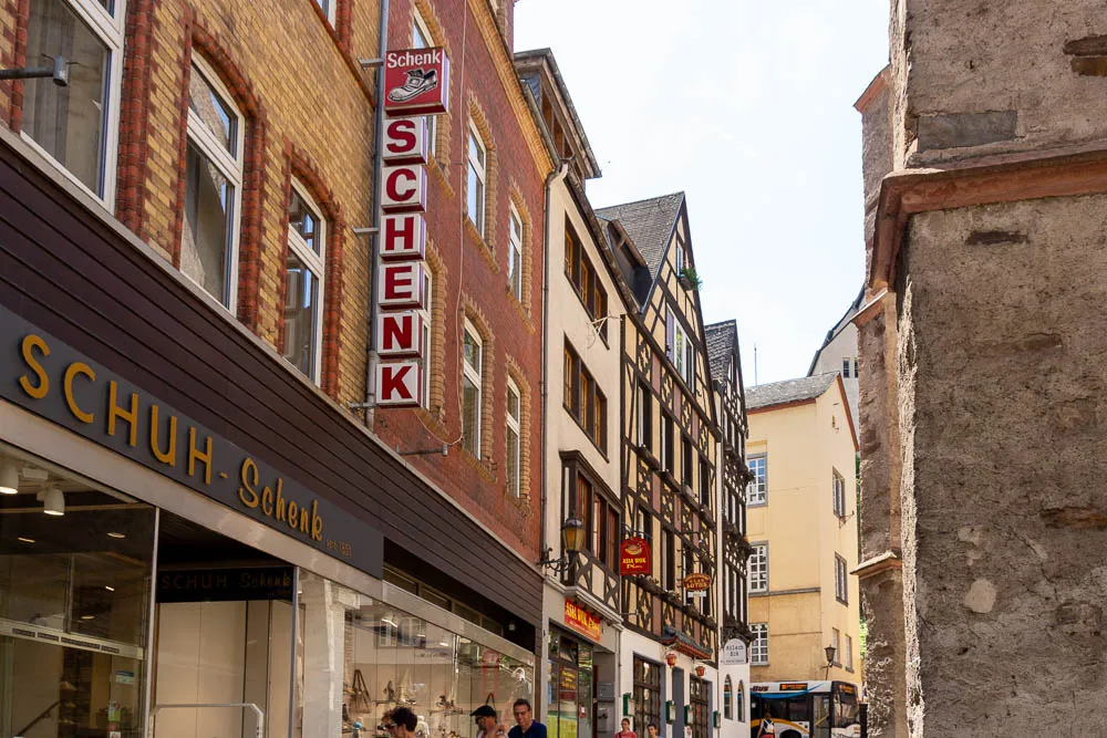 Enge Gasse in der Altstadt von Cochem mit Fachwerkhäusern und einem Bus im Hintergrund.