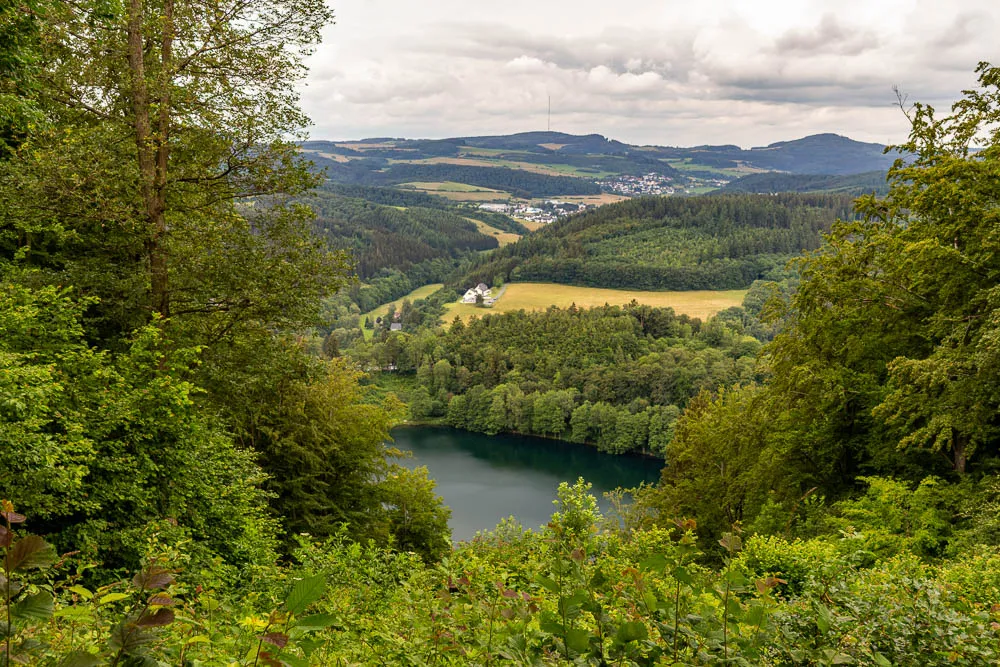 Blick über das Gemündener Maar und die bewaldete Landschaft der Vulkaneifel.