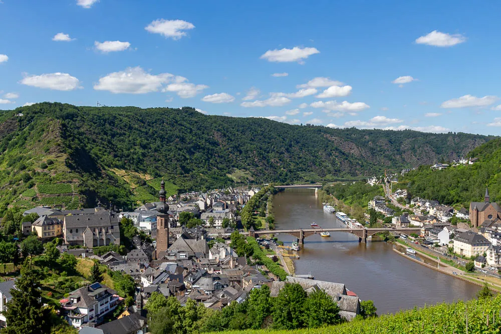 Panoramablick von der Reichsburg auf Cochem und die Mosel mit Weinbergen und Brücken.