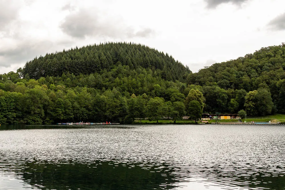 Blick über das Gemündener Maar auf den bewaldeten Kraterrand in der Vulkaneifel.