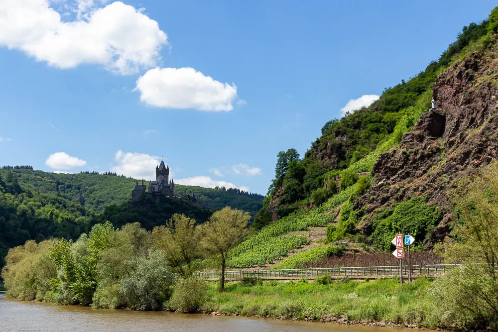 Reichsburg Cochem erhebt sich über der Mosel zwischen Weinbergen und bewaldeten Hängen.