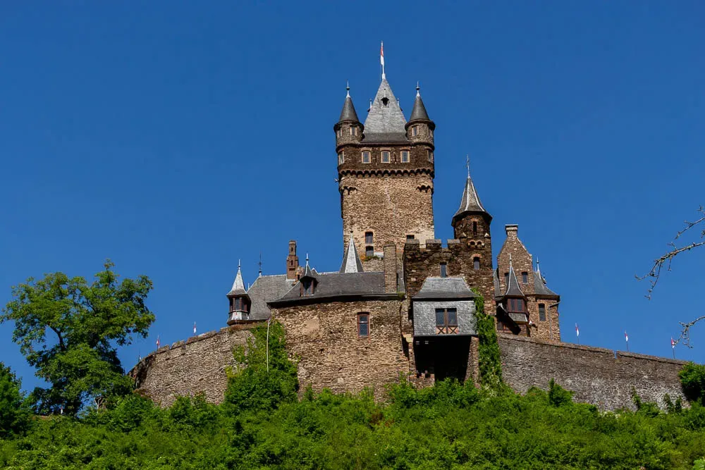 Die Reichsburg Cochem erhebt sich über den Weinbergen an der Mosel.