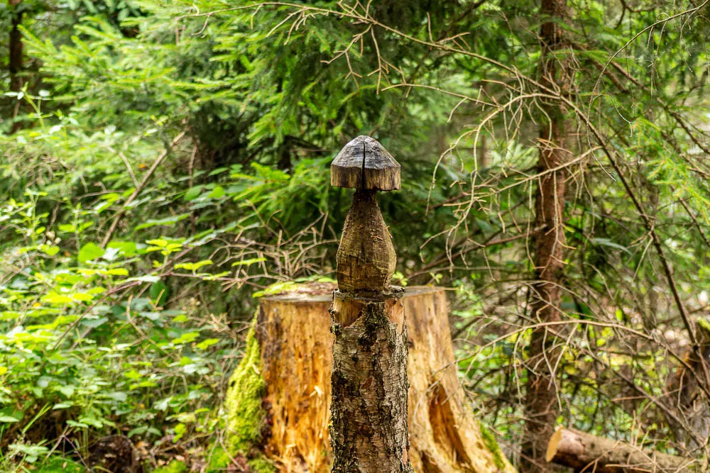 Kleine geschnitzte Holzskulptur auf einem Baumstumpf im Arnsberger Wald.