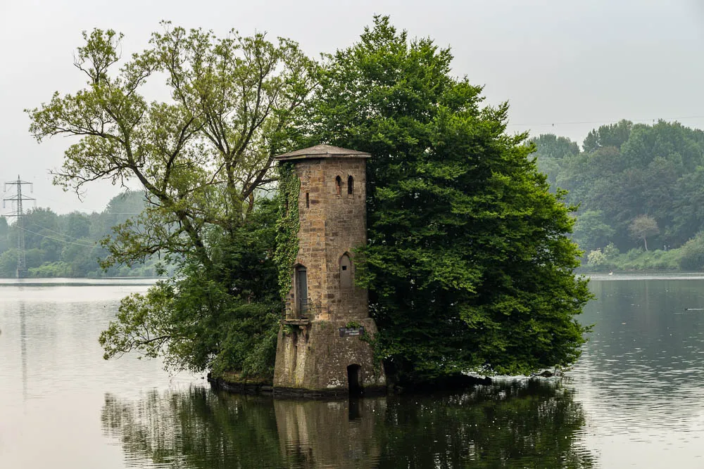 Der Mäuseturm steht auf einer kleinen Insel im Hengsteysee, umgeben von Bäumen und Wasser.