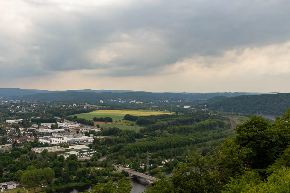 Blick von Hohensyburg über das Ruhrtal mit bewaldeten Hügeln, Feldern und dem Hengsteysee.
