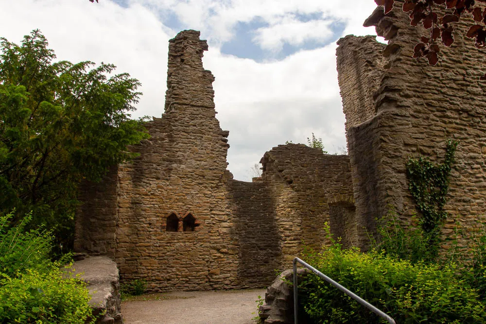 Erhaltene Mauern der Burgruine Hohensyburg stehen zwischen dichtem Grün.