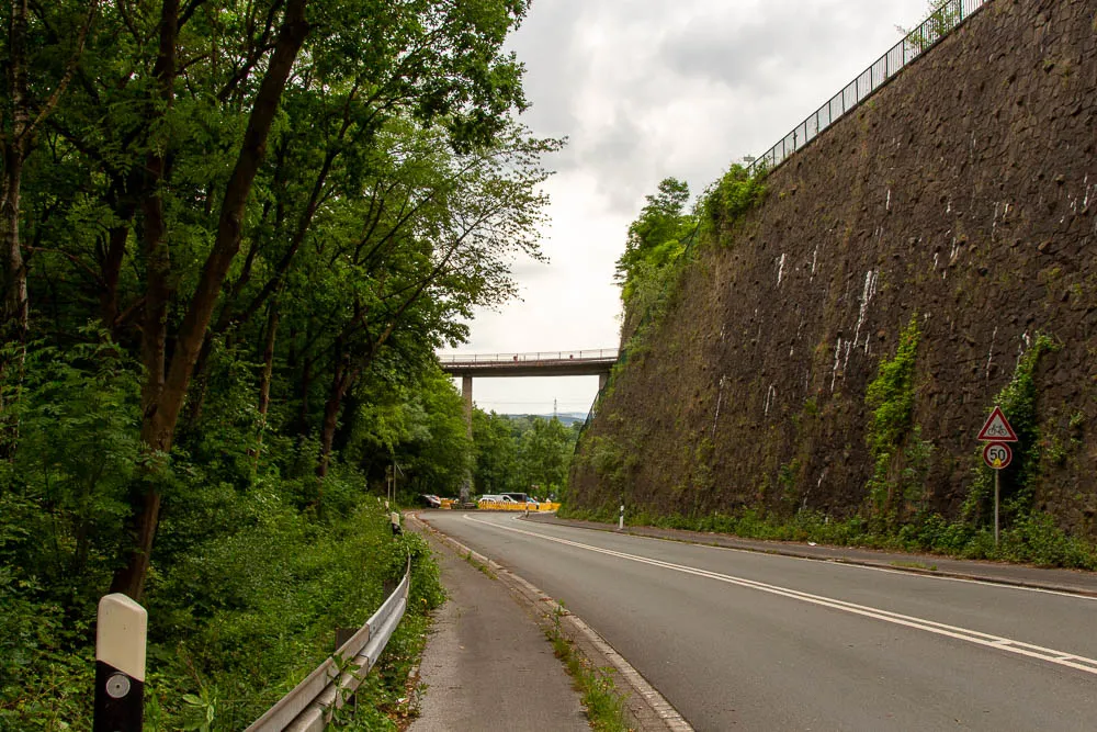 Eine Straße führt von Hohensyburg durch einen bewaldeten Einschnitt in Richtung Hengsteysee.