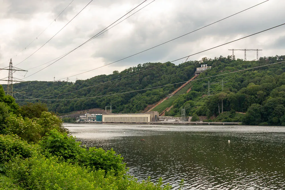 Blick über den Hengsteysee auf das Köppchenwerk mit der markanten Druckrohrleitung am bewaldeten Hang.