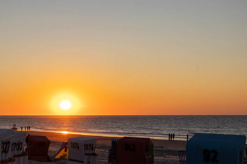 Sonnenuntergang über der Nordsee vor Langeoog mit Strandkörben im Vordergrund. - Untergangsstimmung
