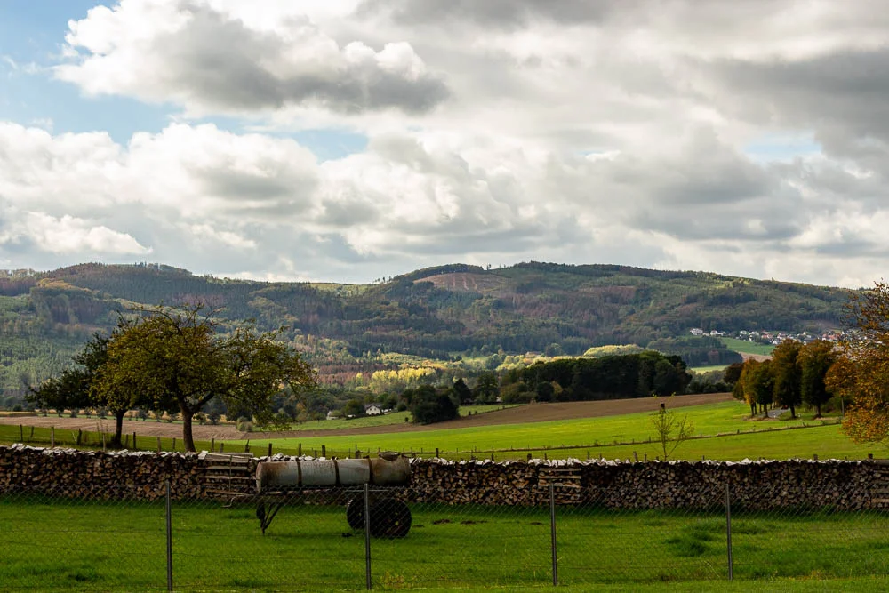 Blick über Felder und Wiesen auf die bewaldeten Hügel des Sauerlands bei Eisborn.